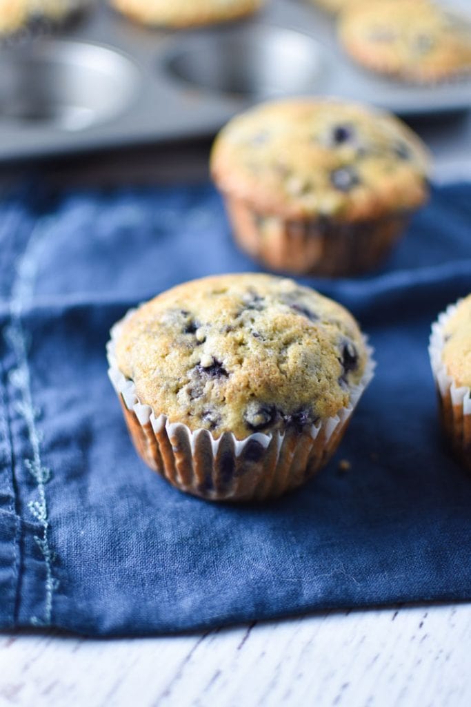 A single blueberry muffin on a blue napkin