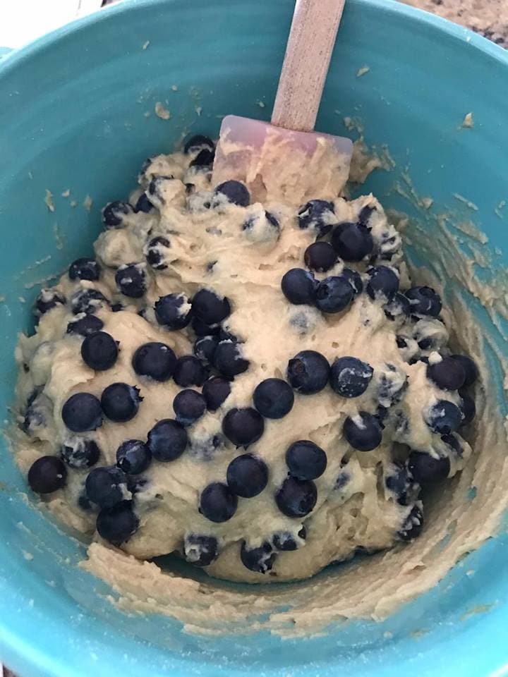 Blue mixing bowl with blueberry muffin batter