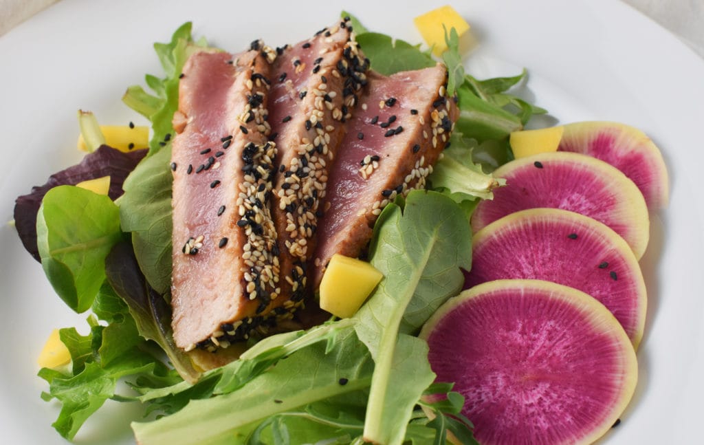 This beautiful ahi tuna salad is made with seared and sesame crusted ahi tuna and a light sesame ginger dressing. The perfect light summer meal, it's super flavorful, healthy, and delicious. 