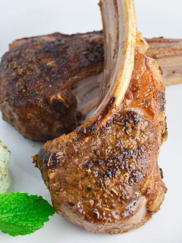 Lamb chops with mint and goat cheese on a white plate