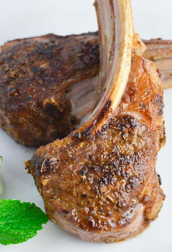 Lamb chops with mint and goat cheese on a white plate