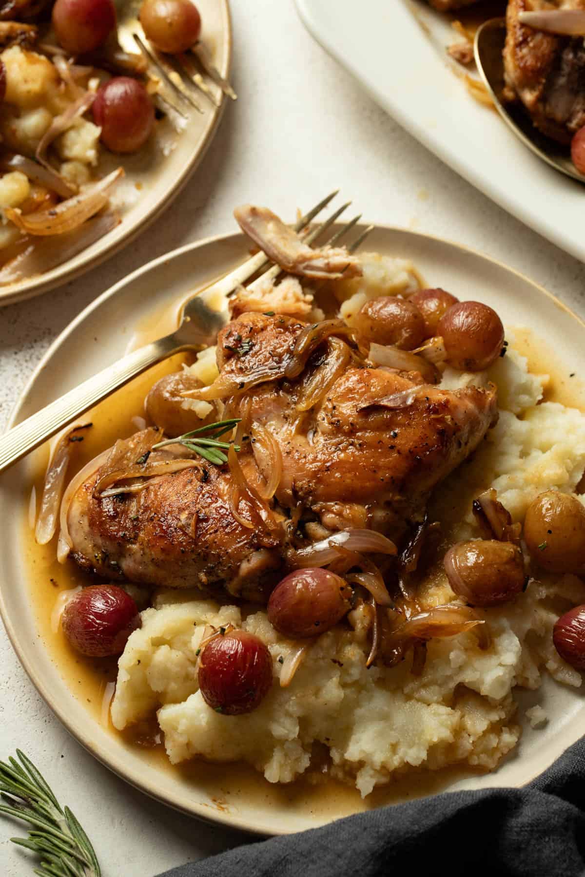 Chicken with grapes on a plate with Boursin mashed potatoes and pan-sauce.