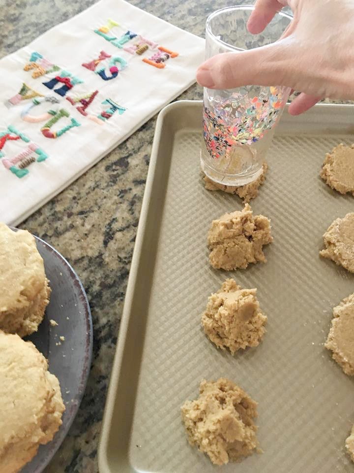 Pressing down Amish butter cookies with sugar coated glass