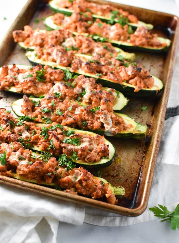 Chicken zucchini boats topped with melted cheese and herbs