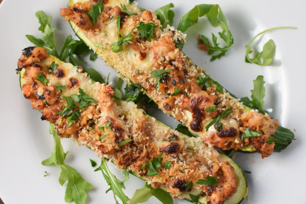 Two stuffed chicken zucchini boats with melted cheese and panko on top