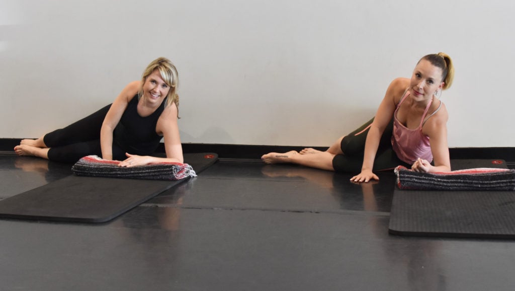 Two young girls doing asana boat pose in yoga studio Stock Photo - Alamy