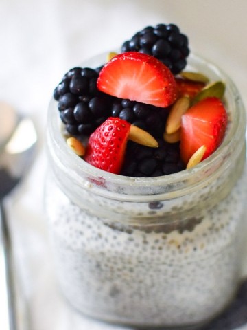 Vanilla chia pudding in a small mason jar with berries on top
