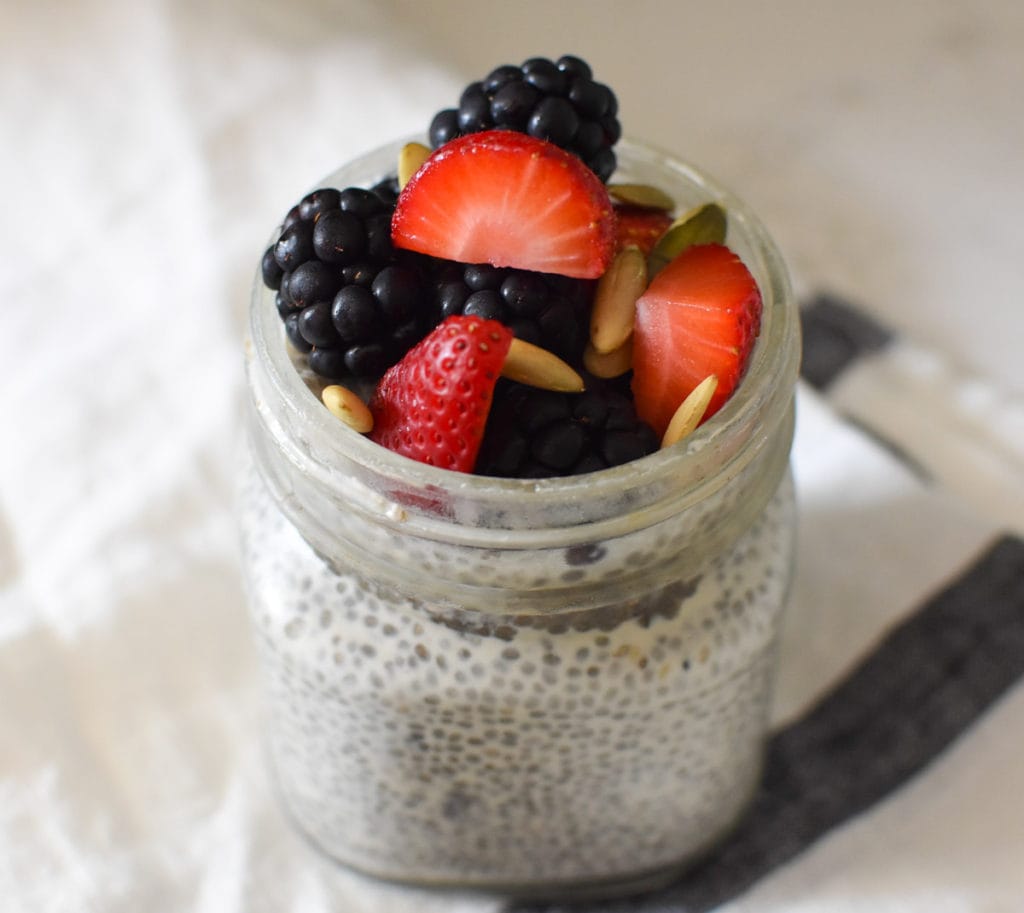 Chia seed pudding topped with berries and pumpkin seeds