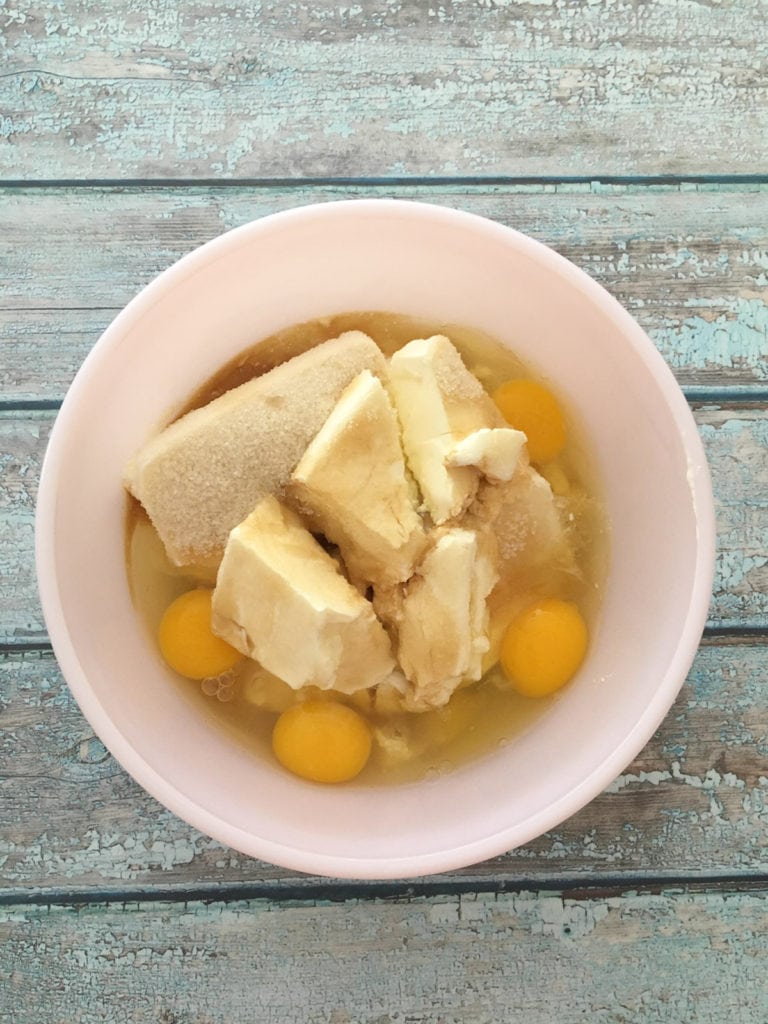 Butter and cream cheese with eggs in a mixing bowl