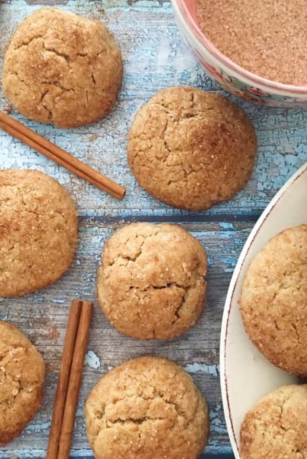 Snickerdoodles with cinnamon sticks and a bowl of cinnamon sugar