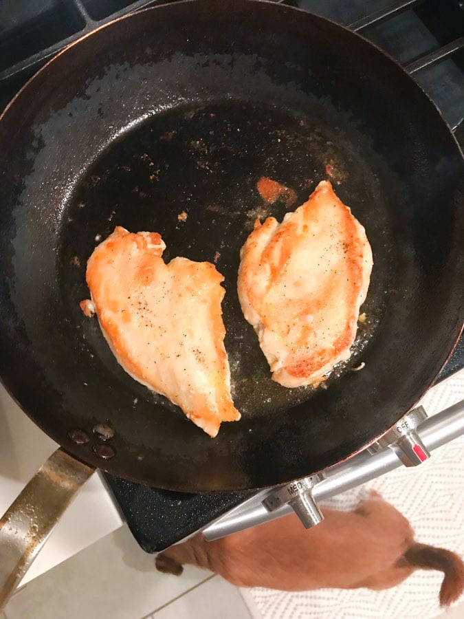 Chicken being seared in pan for chicken marsala