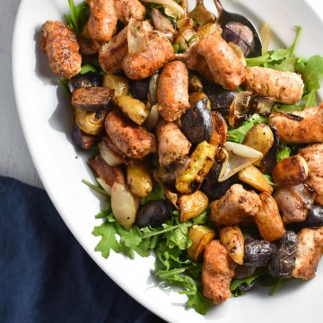 Looking for an easy, one pan dinner? This salad with arugula is topped with sweet roasted shallots, potatoes, and chicken sausage for the perfect, healthy fall meal that's gluten free and whole 30 #healthy #weeknightdinner #migrainediet #whole30
