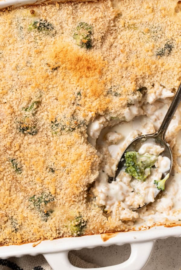 A white baking dish with a cheesy broccoli rice casserole inside.