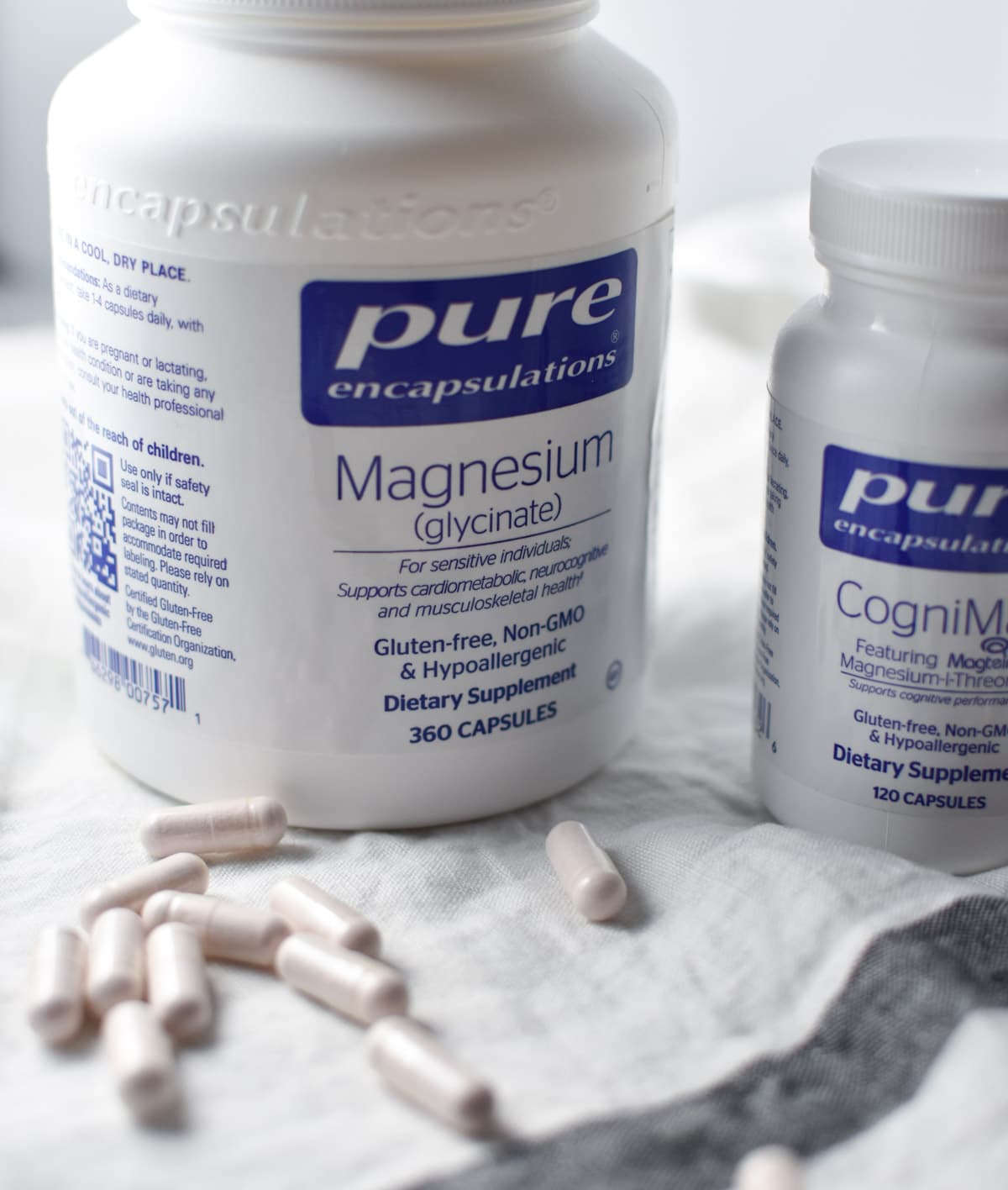 Two bottles of magnesium with supplements on a table.
