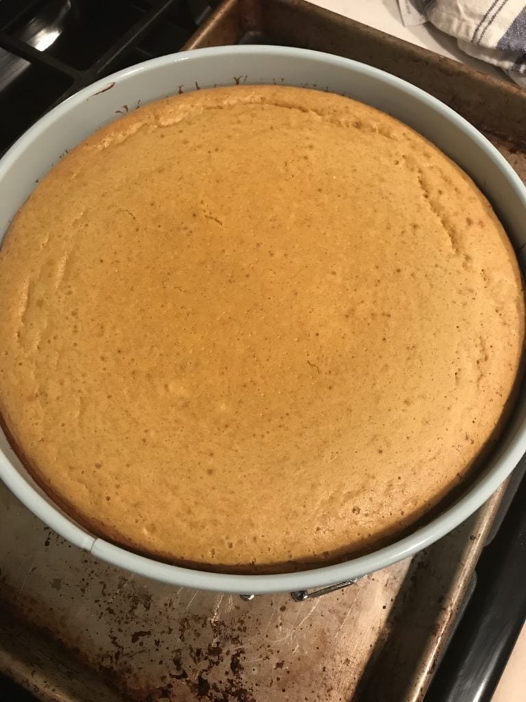 A pumpkin cheesecake out of the oven to show minimal cracking on top. 