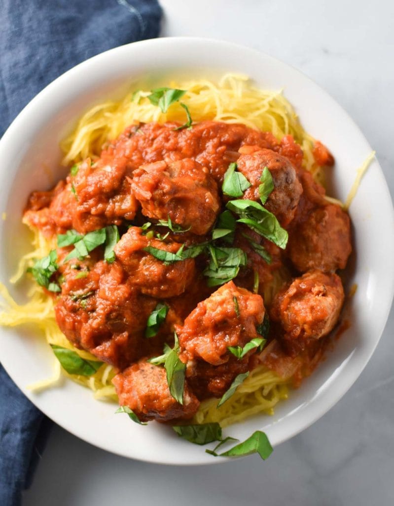 Spaghetti Squash marinara in a white bowl topped with parsley