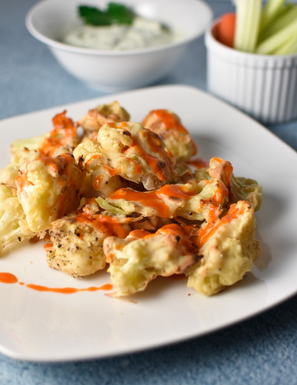 Buffalo cauliflower with faux blue cheese dip is a migraine friendly vegetarian alternative to the traditional game day food. Fresh goat cheese provides a tangy, creamy flavor! #buffalocauliflower #vegetarian #migrainediet