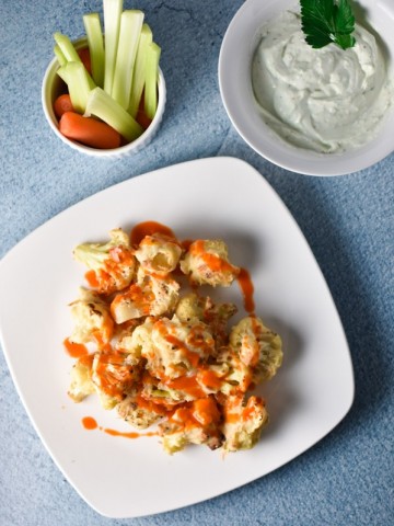 Buffalo cauliflower with faux blue cheese dip is a migraine friendly vegetarian alternative to the traditional game day food. Fresh goat cheese provides a tangy, creamy flavor! #buffalocauliflower #vegetarian #migrainediet