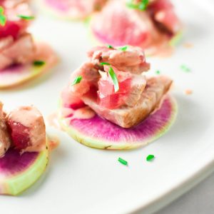 Spicy Tuna mix on top of a watermelon radish with green onion on top