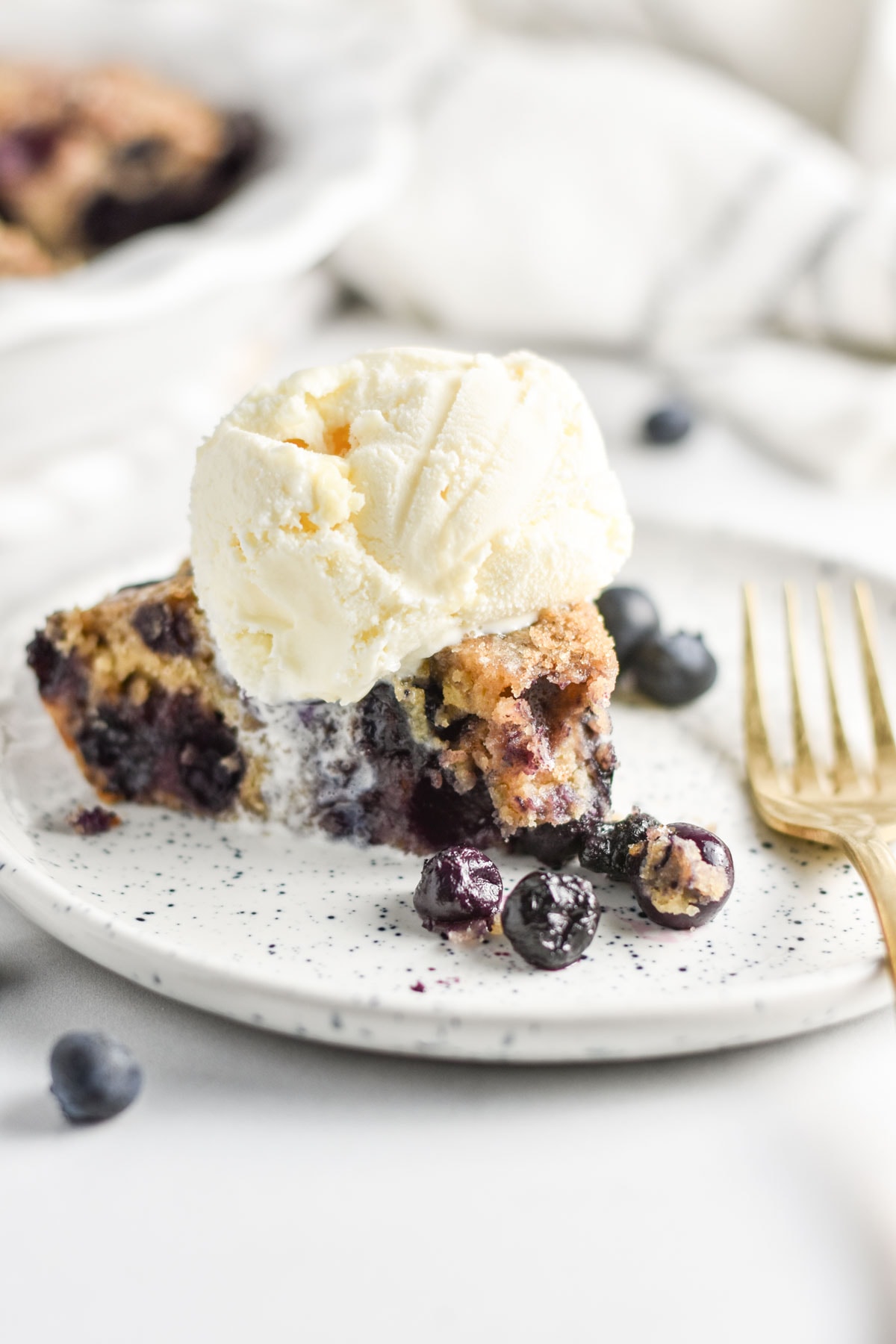 A slice of homemade crustless pie topped with melting vanilla ice cream.