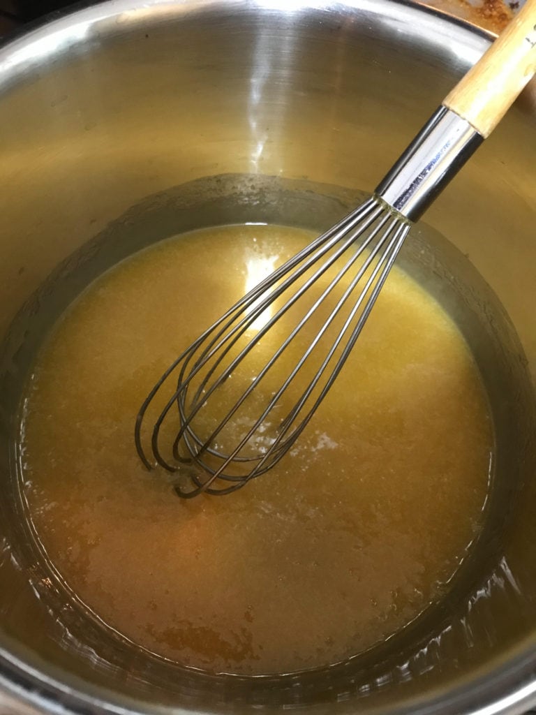Mixing butter and caramel in a steel pot