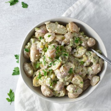 Potato Salad in a bowl with a white towel and parsley