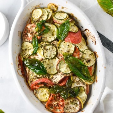 Roasted summer squash, zucchini, tomatoes, shallots, and herbs in a gratin dish with crispy basil