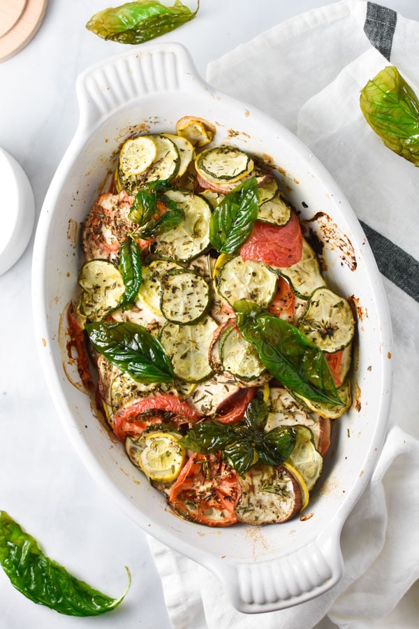 Roasted summer squash, zucchini, tomatoes, shallots, and herbs in a gratin dish with crispy basil