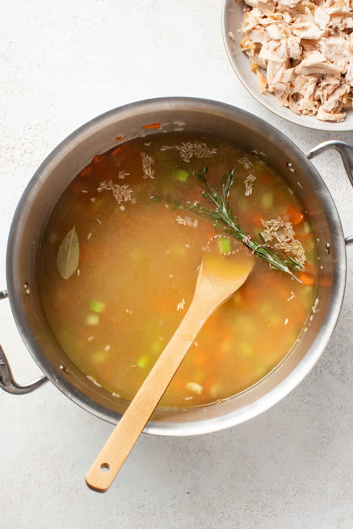 Adding broth and water to the soup pot.