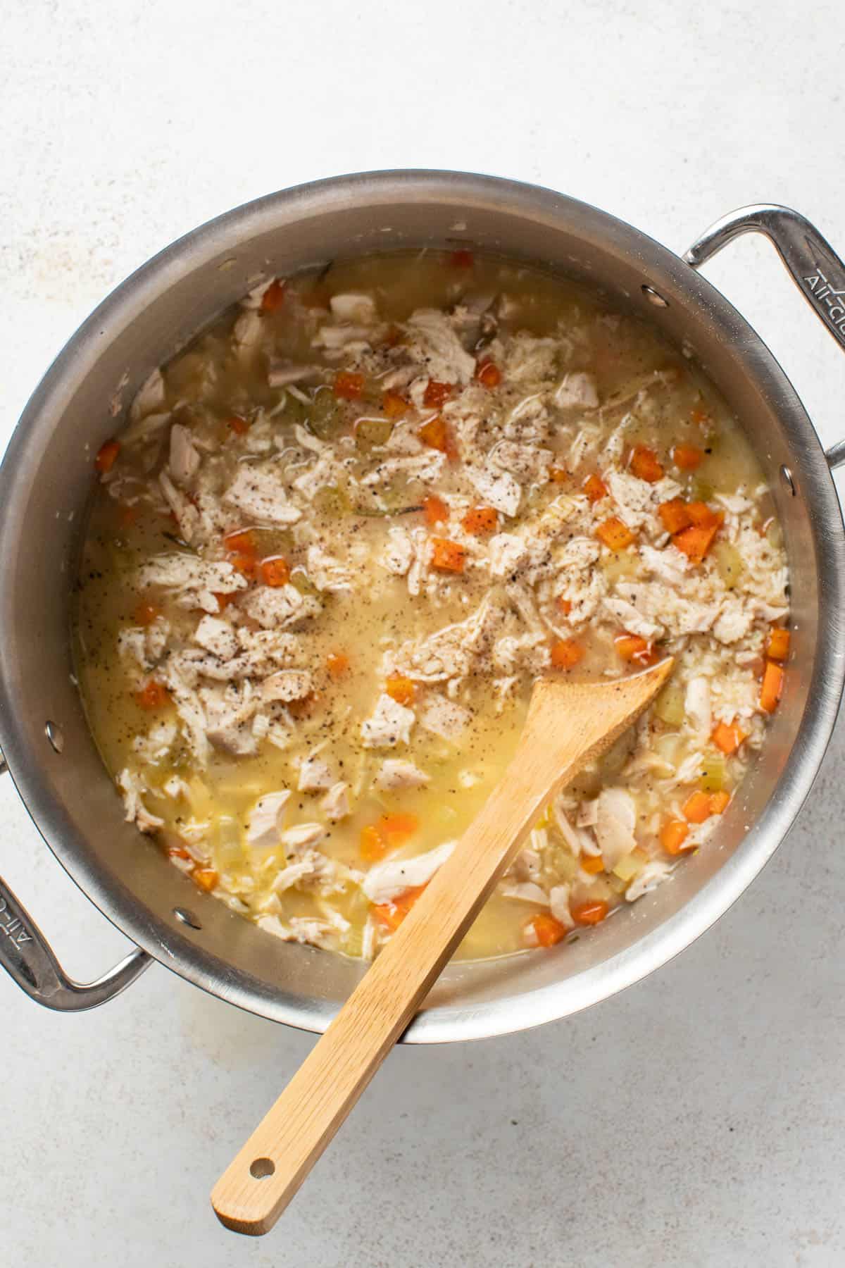 Adding more broth to the finished chicken and brown rice soup.