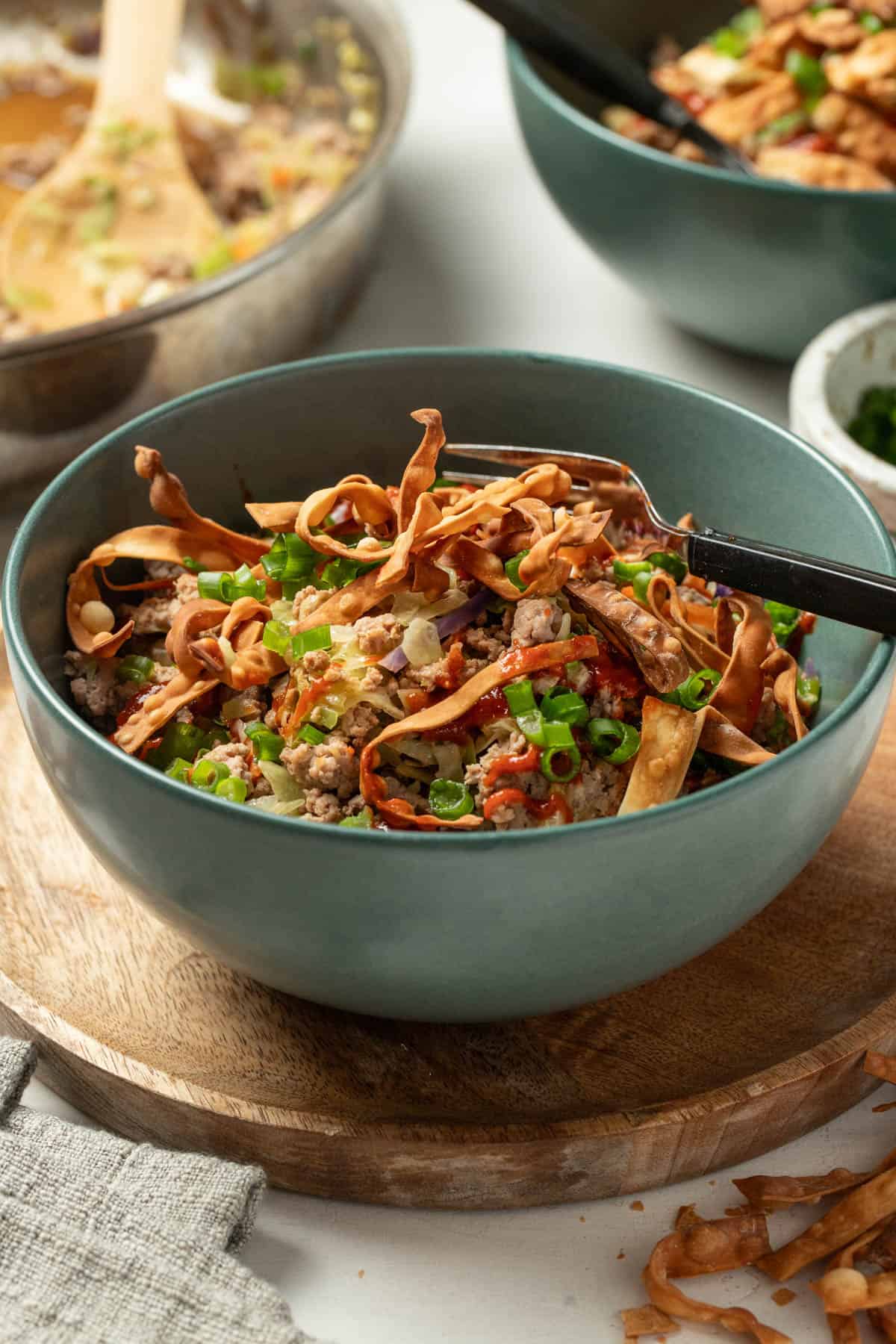 Crispy egg roll wrappers on top of a stir fry bowl.