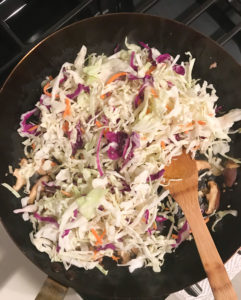 cabbage being sauteed in a pan