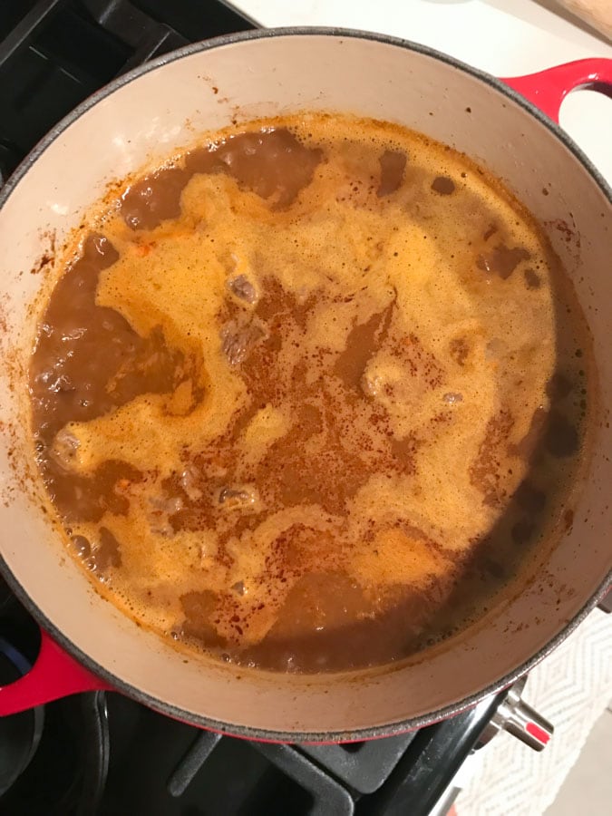 A big pot of texas chili simmering on the stove
