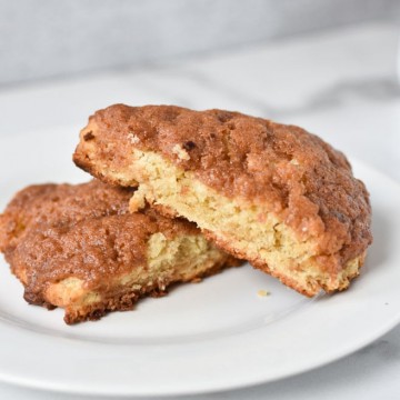 two cinnamon scones stacked on top of each other on a white plate