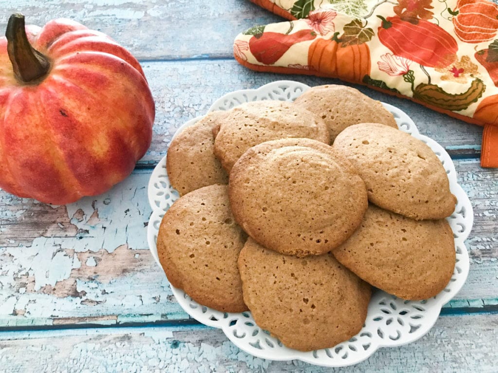 honey cookies on a white plate with a pumpkin and an oven mit