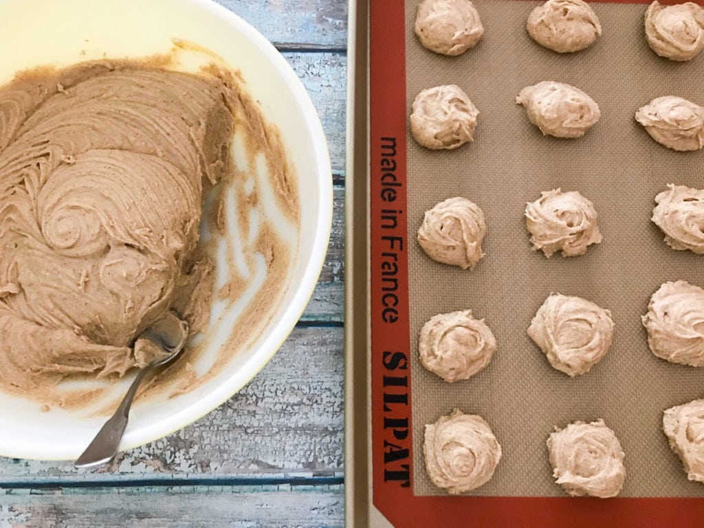 spiced honey cookies batter next to a baking sheet with cookie dough balls