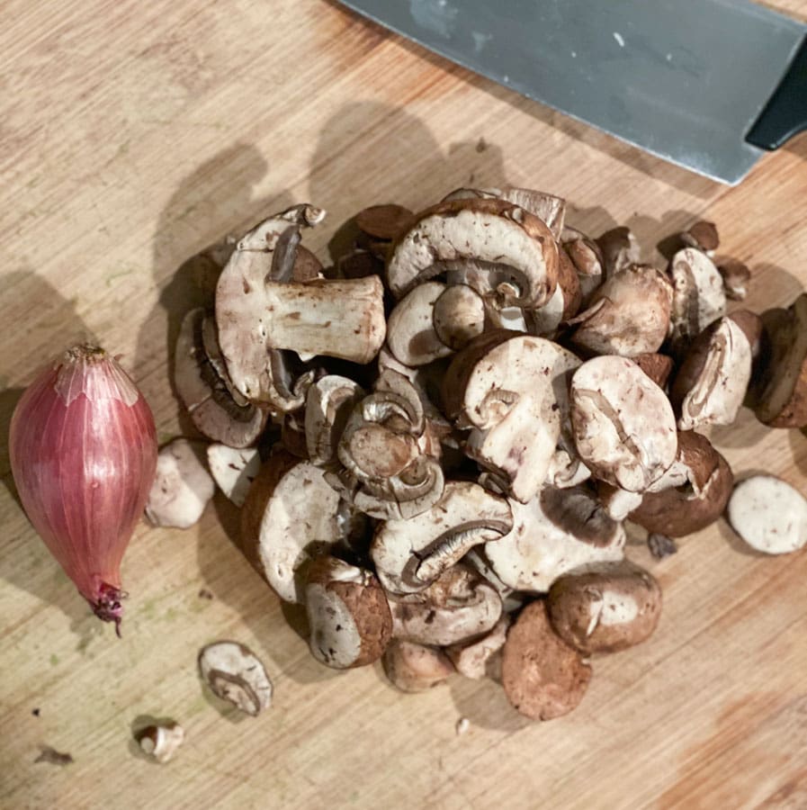 mushrooms and shallots on a cutting board