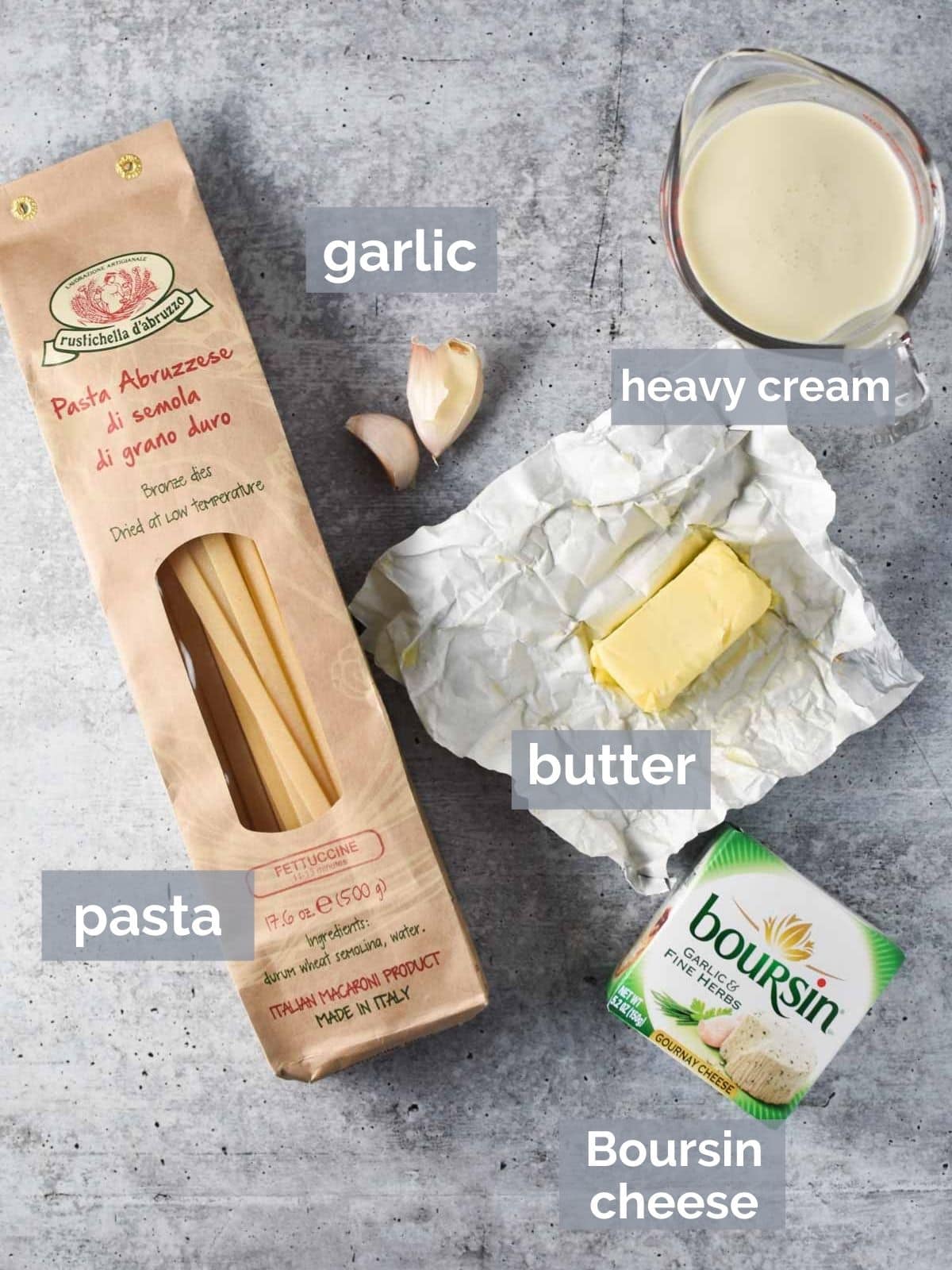 Pasta, garlic, cream, Boursin cheese on a concrete table.