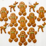 Decorated gingerbread men all lined up next to each other with gingerbread deer