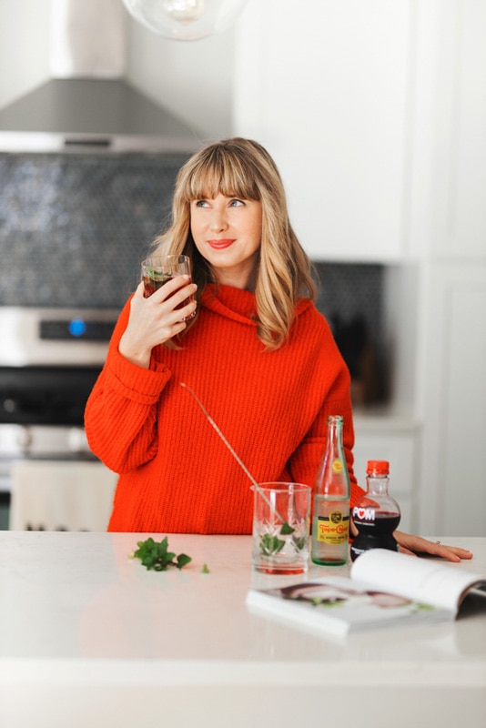 A girl smiling with a holiday drink in her hand