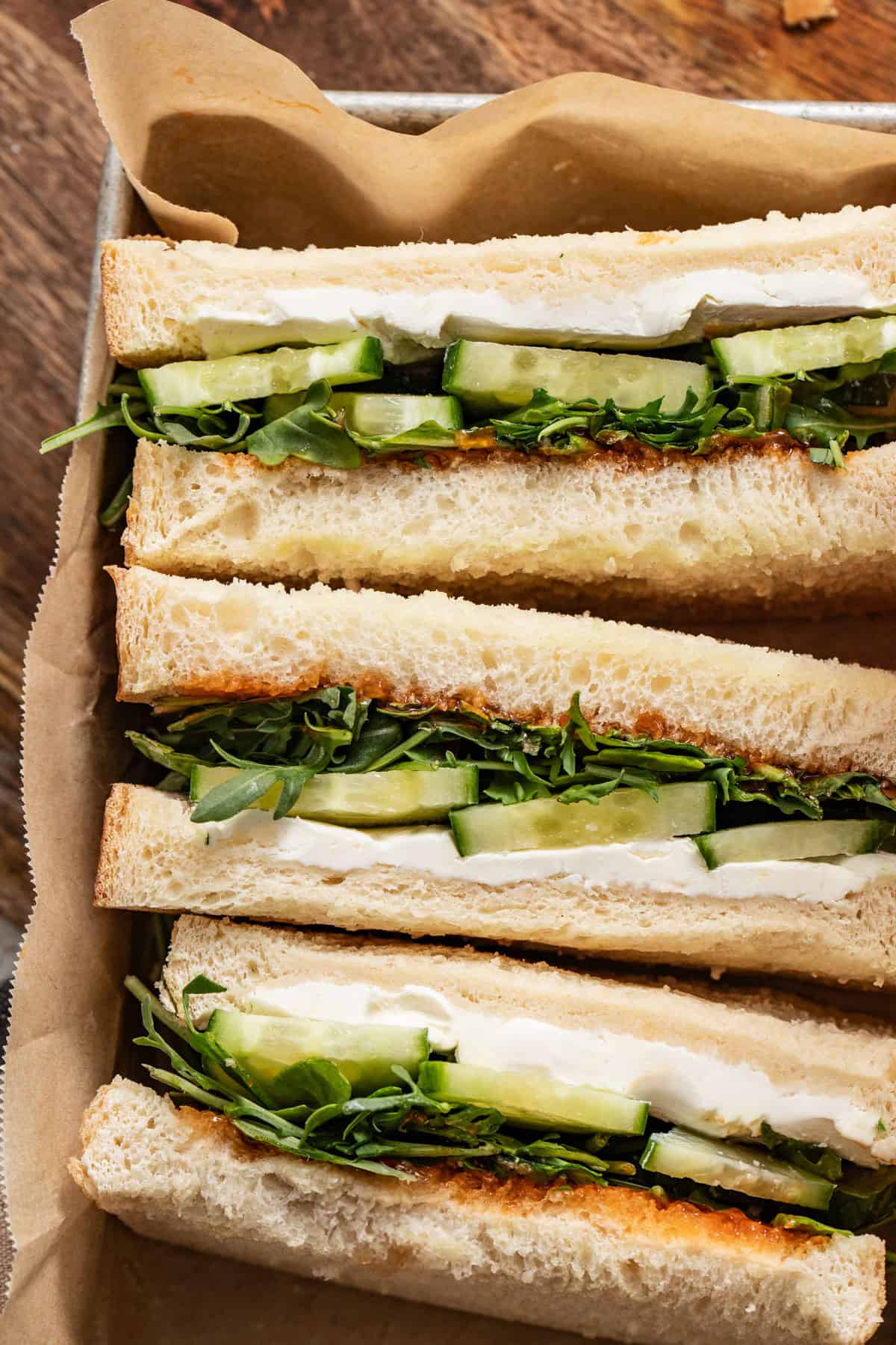 Vegetable sandwiches stacked in a box.