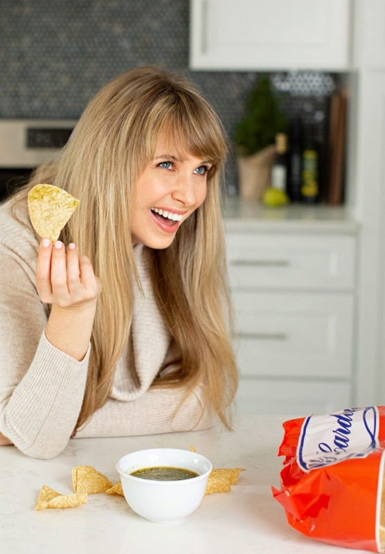 A girl eating a bowl of salsa to test migraine food triggers. 