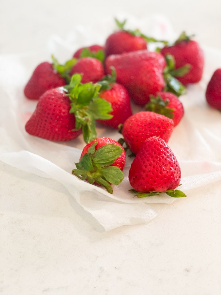 A bunch of washed strawberries on a paper towel.