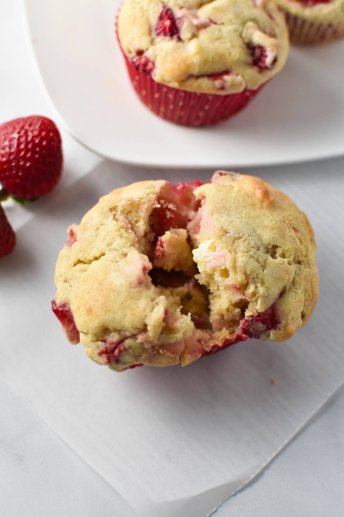 A strawberry cream cheese muffin being pulled open to show the inside.