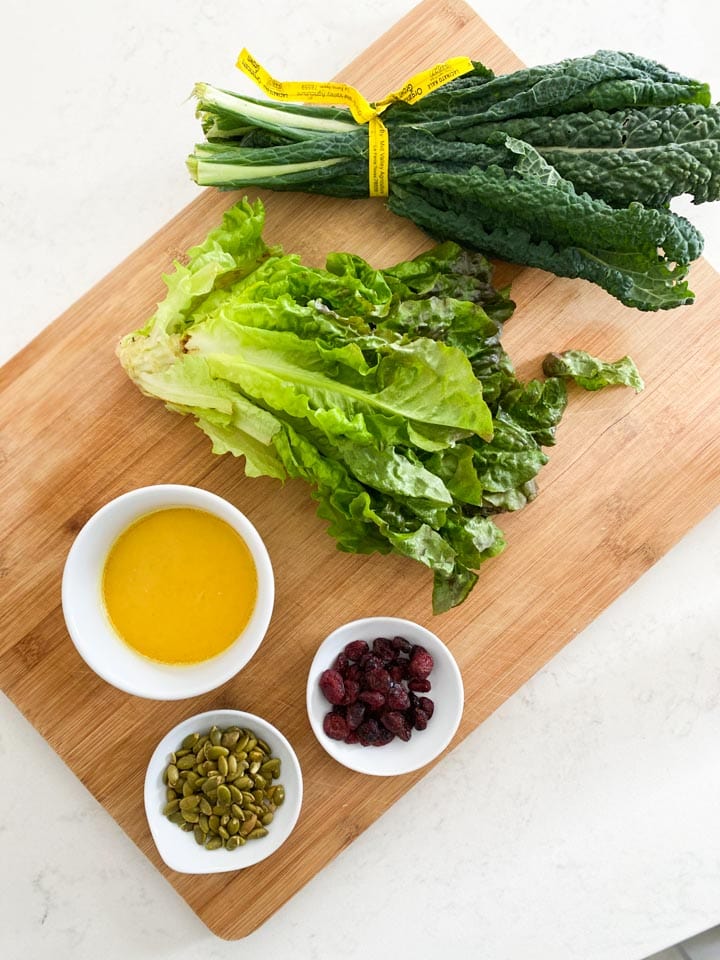 Ingredients for a kale salad on a cutting board