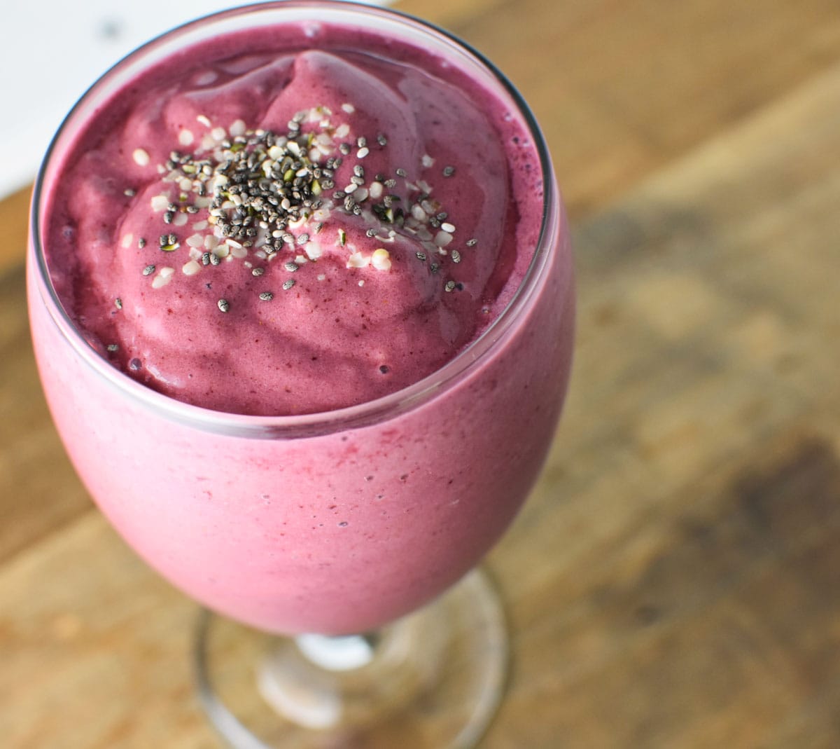A smoothie on a table topped with chia and hemp seeds.