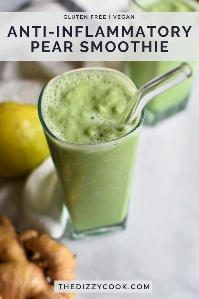A green pear smoothie on a marble table with ginger and a whole pear