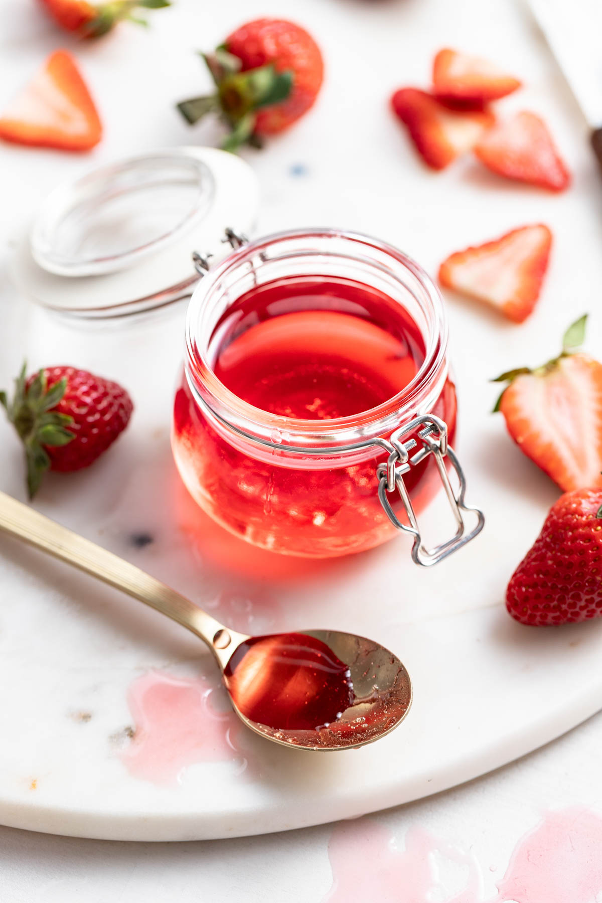 Strawberry syrup in a glass storage container.