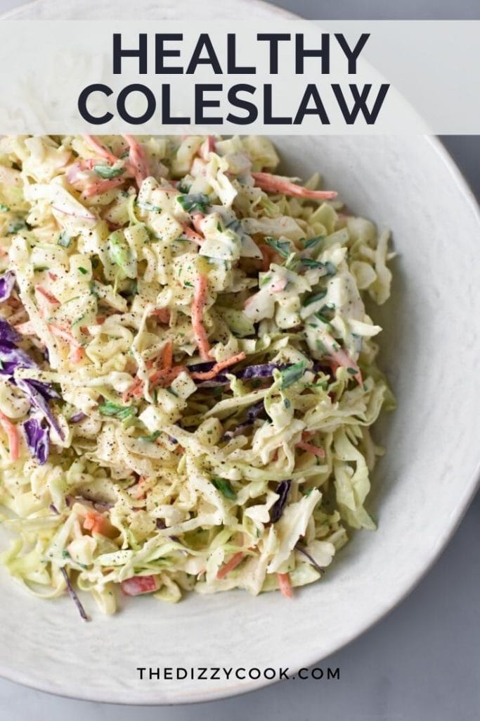 Creamy coleslaw mix of cabbage, carrots, and apples in a white bowl