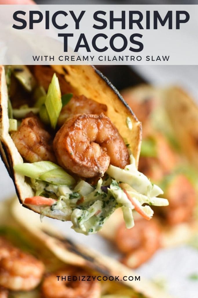 A close up shot of a spicy shrimp taco with creamy slaw coming out of the tortilla